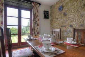 MusburyRose Cottage的用餐室配有木桌和餐具