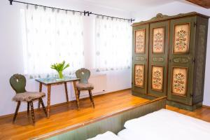 圣迈克尔隆高Hotel Weissenstein的一间卧室配有桌子、两把椅子和一张床