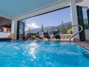 齐勒河谷采尔加拉豪斯公寓酒店的一个带椅子的游泳池,享有山景