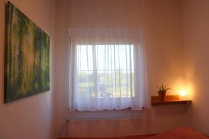 利波特Nyugi-Lak的卧室设有白色窗帘的窗户