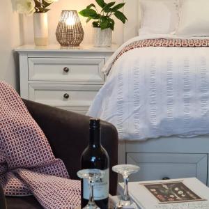 温耶德Kadi House - Unit 2的一间卧室配有一张床和一张桌子及一瓶葡萄酒