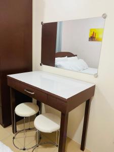 达沃市8 Spatial Condominium的浴室设有梳妆台、镜子和2把凳子