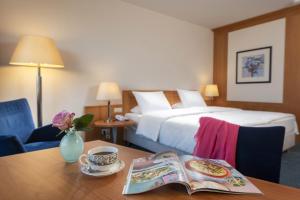美因河畔法兰克福玛丽蒂姆法兰克福酒店的酒店客房,配有一张床和一张桌子,还有一本书