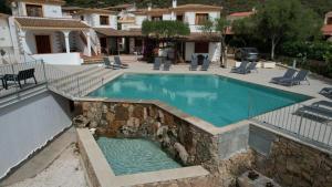 圣特奥多罗Residence Chiaro di Luna的游泳池四周环绕着岩石墙