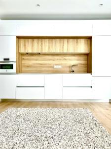 马德里BEST LOFT NEAR REAL MADRID STADIUM的厨房配有白色橱柜和地毯。