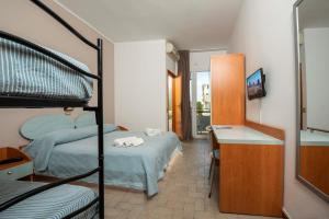 切塞纳蒂科HOTEL GIARDINO的一间卧室配有两张双层床、一张桌子和一张床。