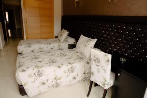 贝尼迈拉勒Hotel La Luna的一间卧室配有一张床和一把椅子