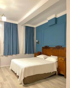 斯库台Promenade Hotel的一间卧室配有一张带蓝色墙壁的大床