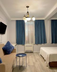 斯库台Promenade Hotel的一间卧室配有床、沙发和蓝色窗帘