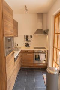 劳里斯Martina 6 by SMR Rauris Apartments - inc Spa and National Summercard - near Gondola的厨房配有木制橱柜和炉灶烤箱。