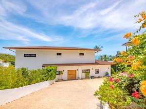 湄南海滩Villa AUREA Sea View的车道和鲜花的房子