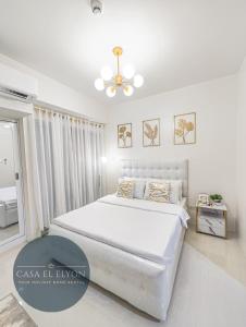 达沃市White Nordic Fully-Furnished Studio at INSPIRIA的白色卧室配有床和吊扇