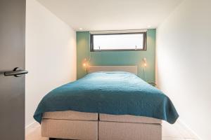 阿尔克马尔Berger Lodge的一间卧室配有一张带蓝色毯子的床