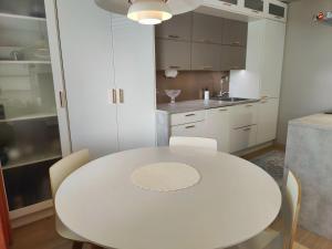 罗瓦涅米Lovely cityhome的白色的厨房配有白色的桌子和椅子