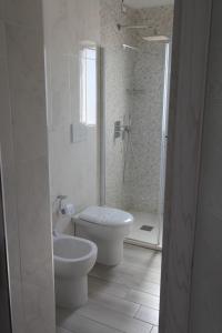 切萨雷奥港Hotel Paladini的白色的浴室设有卫生间和淋浴。