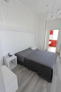 切萨雷奥港Hotel Paladini的一间卧室配有一张大床和一个吊灯。
