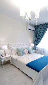 第聂伯罗Тиффани апартаменты的卧室配有一张蓝色色调的大型白色床。