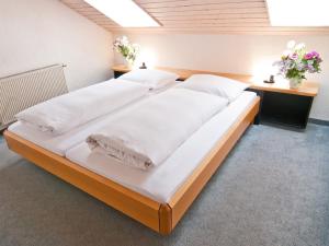 普夫龙滕基恩伯格公寓的一张配有白色床单和枕头的大床