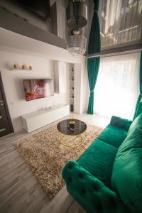 康斯坦察Toto’s Apartment的客厅配有绿色沙发和桌子