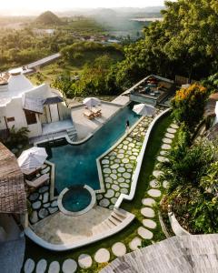 BumbangDome Lombok的享有带遮阳伞的游泳池的空中景致