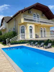 巴拉顿菲赖德皇家别墅酒店的房屋前有游泳池的房子