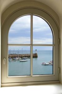 勒帕莱Les Appartements d'Alexandre的享有海港景色的拱形窗户