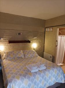 皮拉米德斯港De Luna的一间卧室配有一张床,上面有两条毛巾