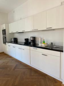 德累斯顿grosszügiges Apartment mit Blick zur Frauenkirche的厨房配有白色橱柜和黑色台面
