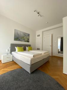 德累斯顿grosszügiges Apartment mit Blick zur Frauenkirche的白色卧室配有一张带黄色枕头的大床
