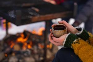 尤卡斯耶尔维Reindeer Lodge的火前喝咖啡的人