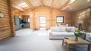 莫珀斯Aspen Lodge, Amazing New Log Cabin with Hot Tub - Sleeps 6 - Felmoor Park的小木屋内带白色沙发的客厅