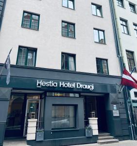 里加Hestia Hotel Draugi的一座酒店大楼,上面有印地安尼图斯酒店药物的标志