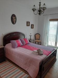 纳扎雷MARIA INÊS HOUSE的一间卧室配有一张大床,提供粉色和紫色枕头