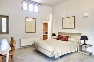 爱琴娜岛Nikolaou residence的白色的卧室设有床、桌子和窗户
