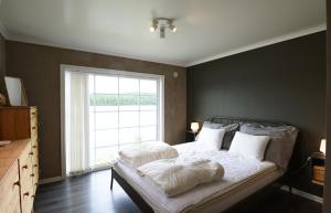 阿尔维卡Cozy holiday home with its own jetty and panoramic views of Norra Orsjon的卧室配有带白色枕头的床和窗户。