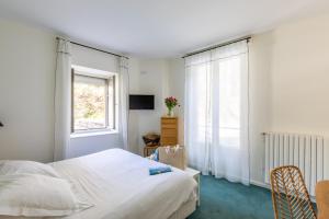 迪纳尔拉瓦雷酒店的白色的卧室设有床和窗户