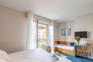 迪纳尔拉瓦雷酒店的一间卧室配有一张床、一张书桌和一个窗户。