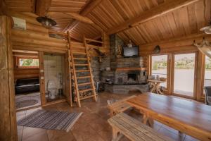 派尔努Marguse Metsamajad的小木屋客厅配有木桌和壁炉