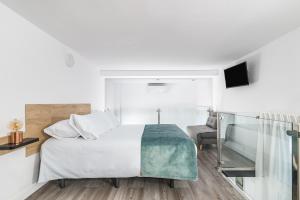 大加那利岛拉斯帕尔马斯Open Sea Suites的白色卧室配有床和椅子