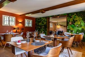 BarretaineMaison Zugno Hôtel & Spa的餐厅设有木桌和椅子,种有植物