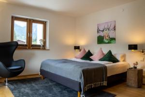 比伯维尔Monte Vita Tirol - Apartments的卧室配有床、椅子和窗户。