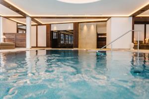 齐勒河谷采尔布劳酒店的一座位于大楼内的蓝色海水室内游泳池