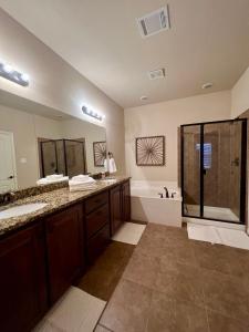 普莱诺Luxury Legacy West Townhouse的大型浴室设有2个水槽和淋浴。