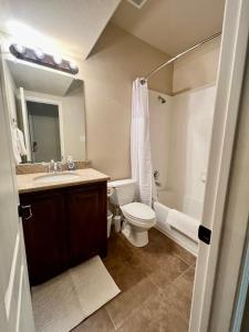 普莱诺Luxury Legacy West Townhouse的浴室配有卫生间、盥洗盆和浴缸。