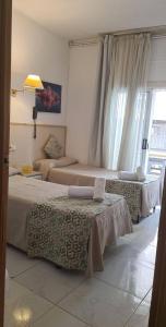 塔拉戈纳塔拉戈纳阿罕布拉旅馆的酒店客房设有两张床和窗户。