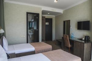 巴统Old Garden Hotel Batumi的酒店客房配有两张床和一张书桌