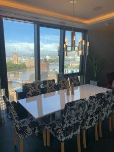 伦敦Parliament House - Luxury Penthouse的一间带桌椅和大窗户的用餐室