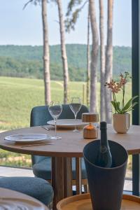 MutignyLOISIUM Wine & Spa Hotel Champagne的一张带两杯酒和一瓶葡萄酒的木桌