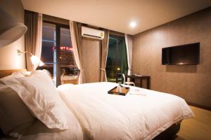 曼谷曼谷C U酒店 - SHA Plus的酒店客房,配有床和电视