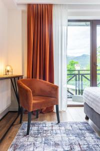 梅斯蒂亚Hotel Chatini Mestia的卧室在窗户前配有椅子